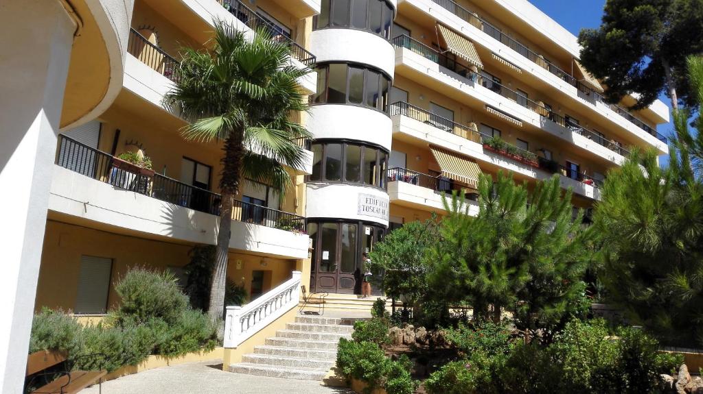 a building with a palm tree in front of it at Apartamento Tosca Mar in Moraira