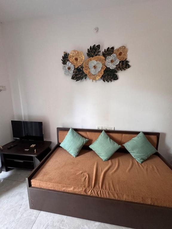 a bedroom with a bed with flowers on the wall at Estudio 007, Palolem in Canacona