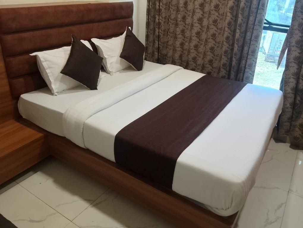 a bed with black and white sheets and pillows at Hotel Sunlight in Ahmedabad