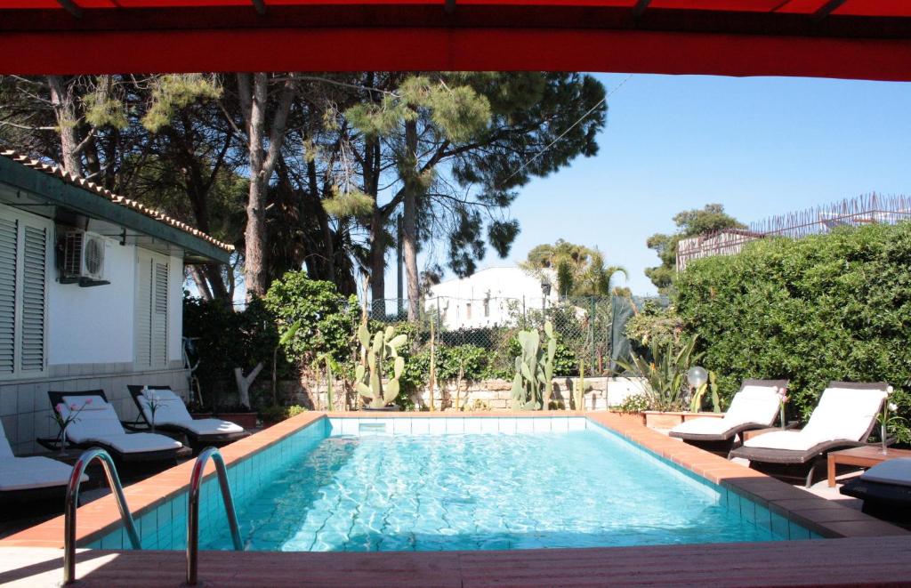 a swimming pool with lounge chairs next to a house at Oasi Del Gabbiano in Syracuse
