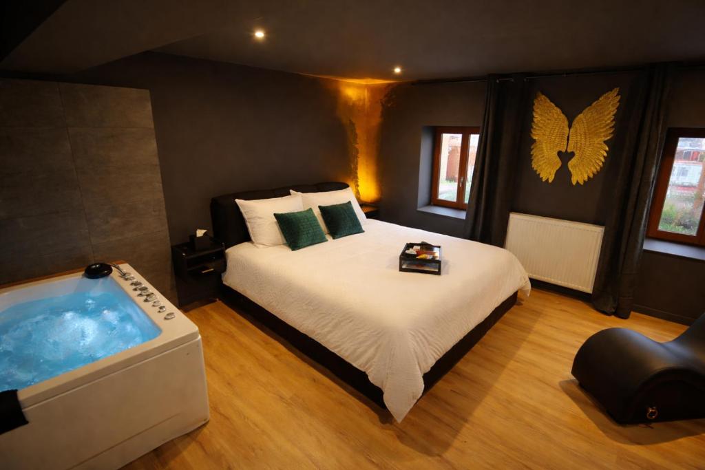 a bedroom with a large bed and a tub at Le Secret' - Balnéo - Romantique Room in Pélussin