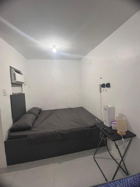 a bedroom with a bed and a desk with a computer at Alilonch Transient in Mangangbukol