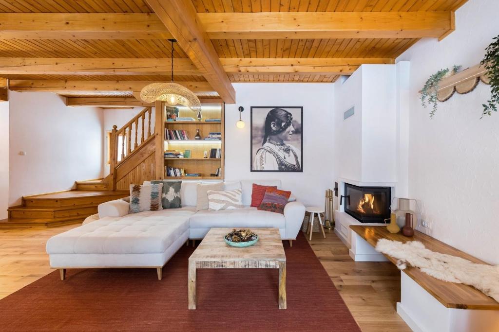 a living room with a white couch and a fireplace at Heritage Villa Predelut - Fireplace & Baby Crib in Predeluţ