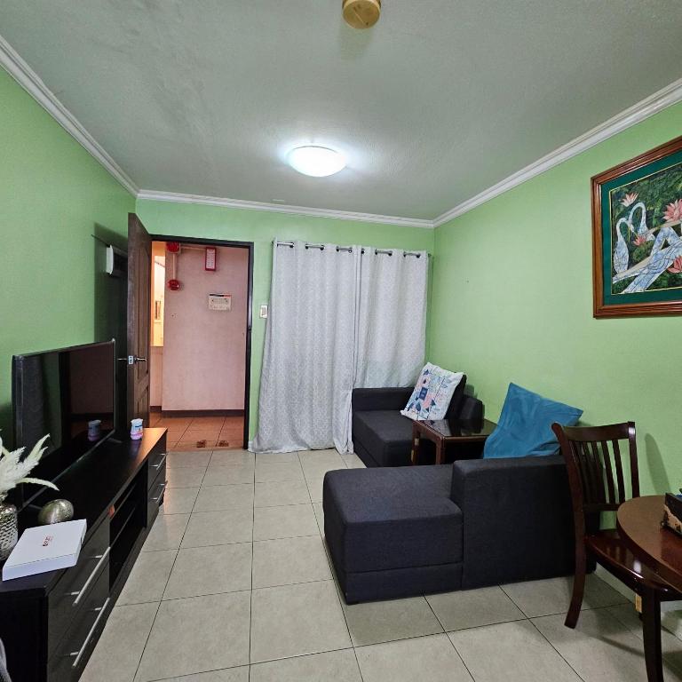 a living room with a couch and a tv at One oasis condo 1bedroom Ltype in Davao City