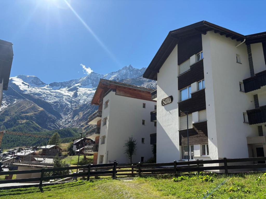 a building on a hill with mountains in the background at Salü 5 in Saas-Fee