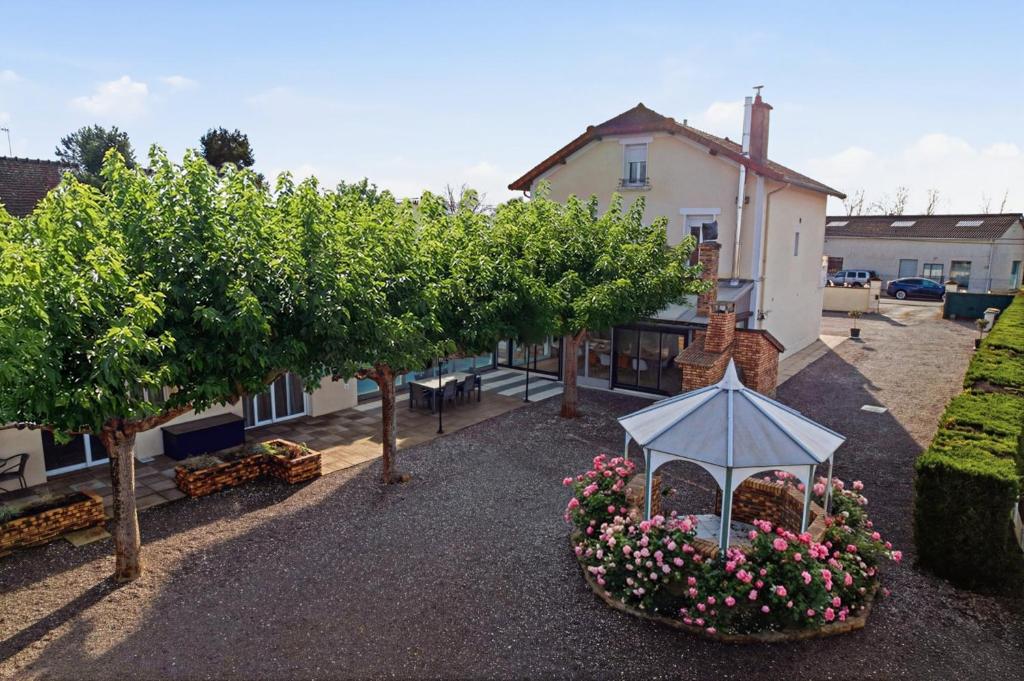 a garden with trees and a gazebo in front of a house at L'écrin fleuri in Allerey