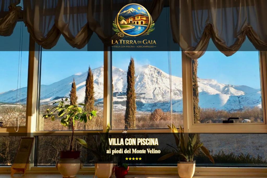 a window with a view of a snow covered mountain at La Terra di Gaia in Magliano deʼ Marsi
