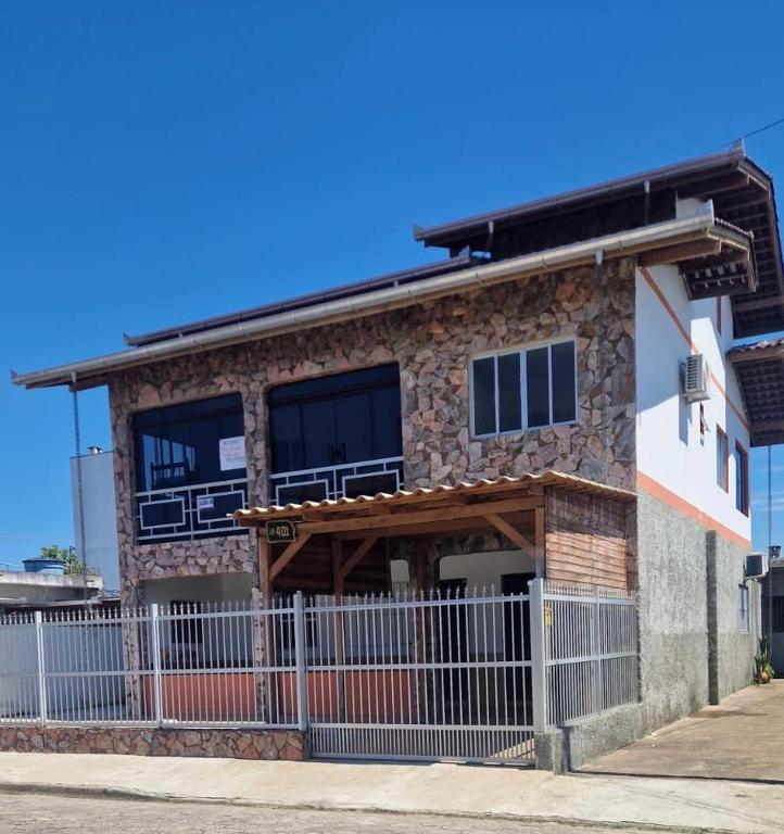 a building with a fence in front of it at Pousada Ju Haus in Navegantes