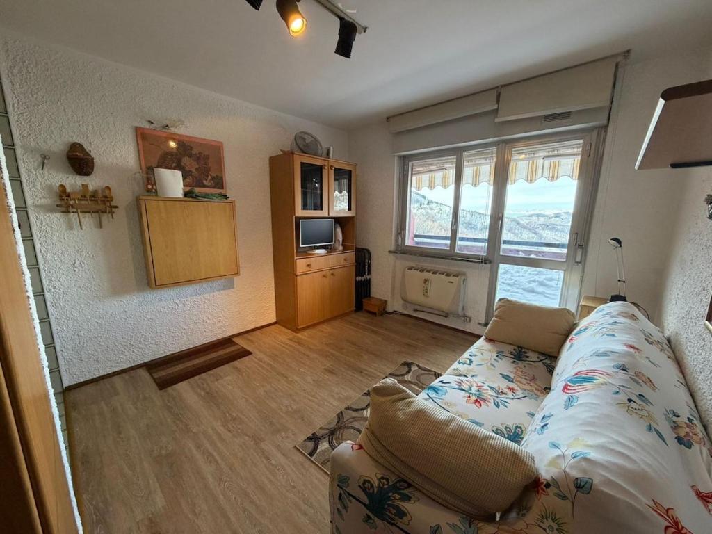 a living room with a couch and a large window at Casa Vacanze S&B in Viola