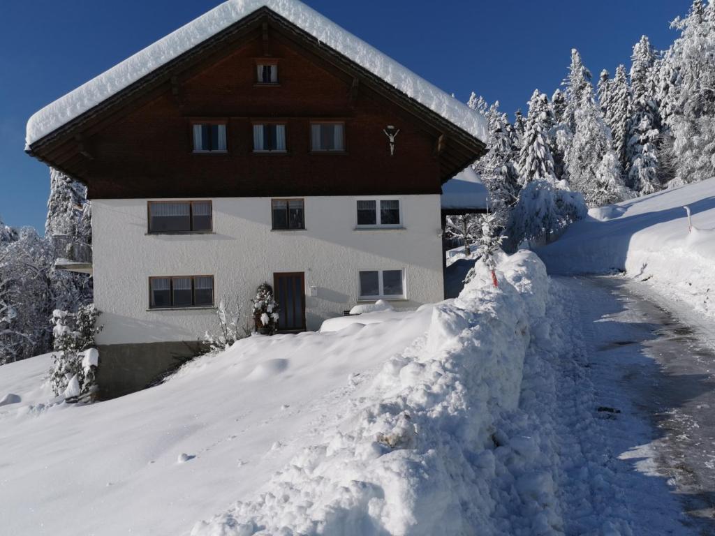 a house in the snow with a pile of snow at Ferienwohnung Panorama in Doren