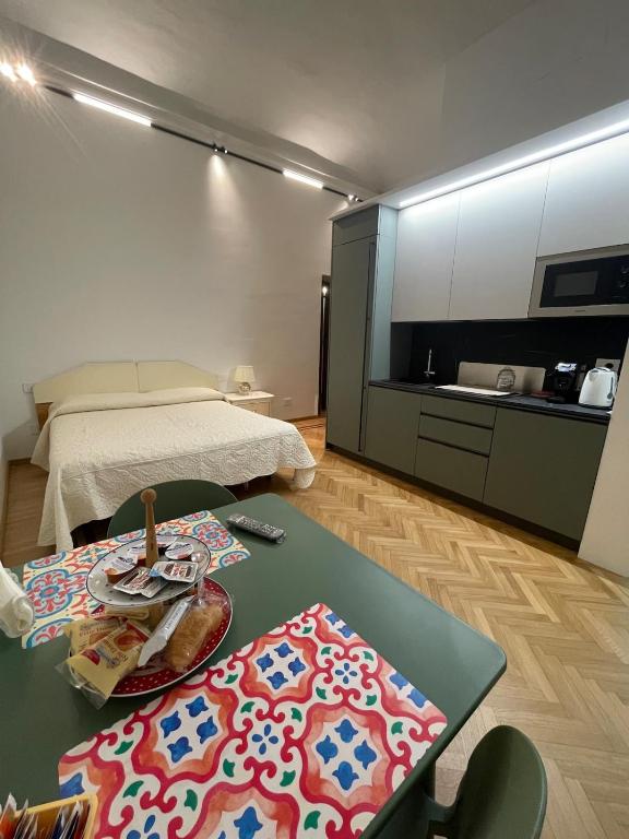 a living room with a bed and a table with a tableasteryasteryasteryastery at Casa Ferrara in Novara