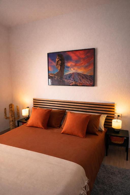 a bedroom with a bed with a painting on the wall at Alma Del Sur Tenerife in Arona