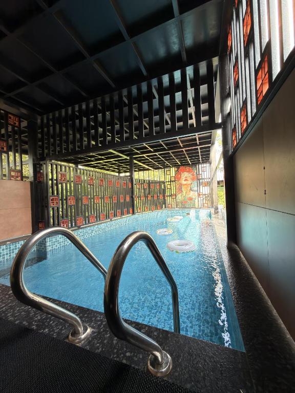 a swimming pool with a metal hand rail in a building at Oblue Private Pool Villa in Cherai Beach