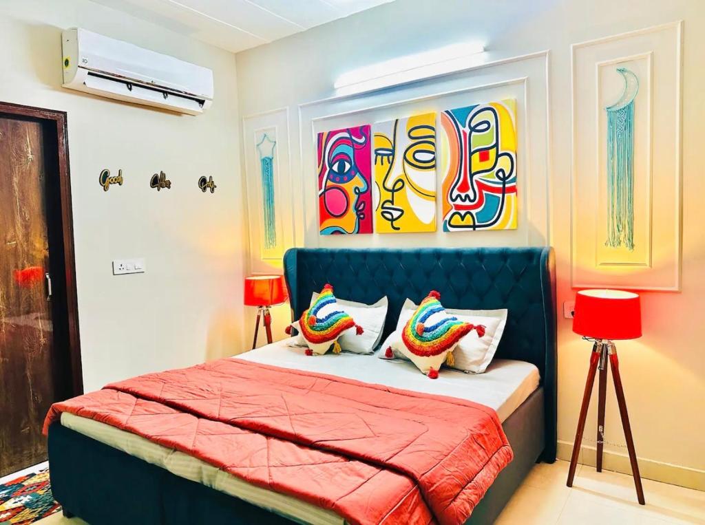 a bedroom with a bed with a blue head board at Vogue- Lavish collection in Zirakpur