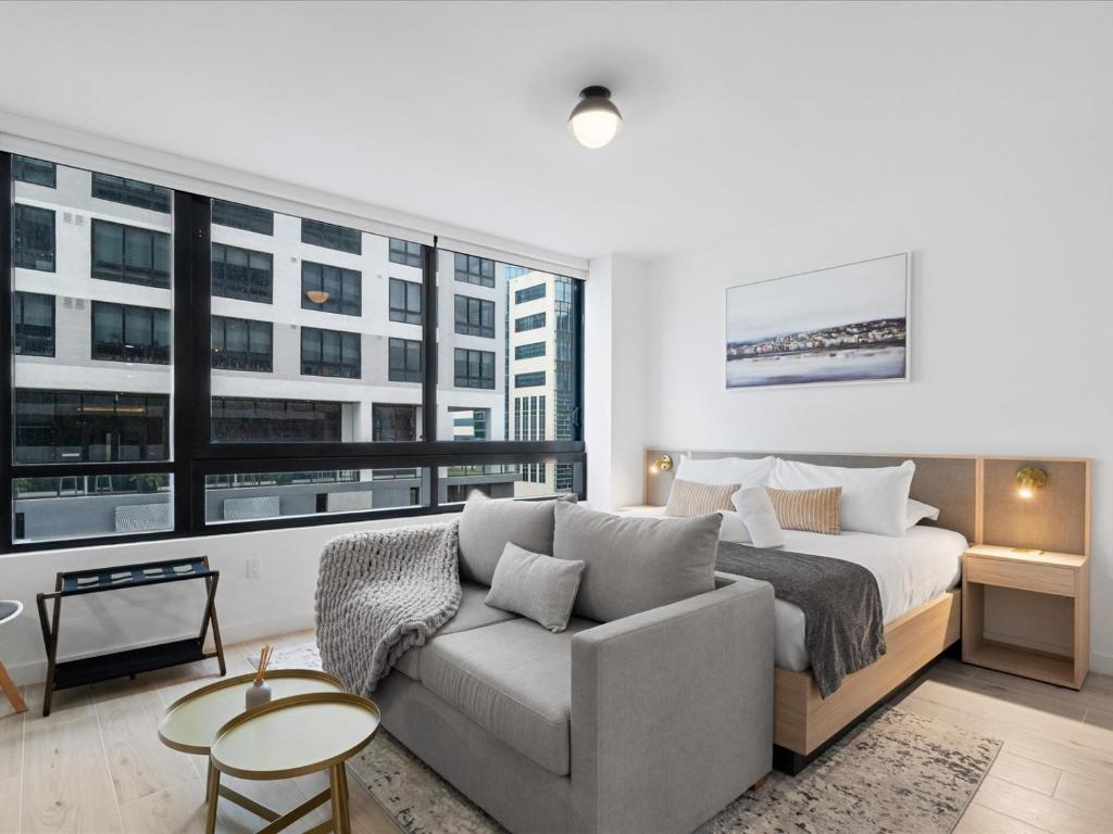 a bedroom with a bed and a couch in front of a window at Stylish Studio in Downtown Location in Miami