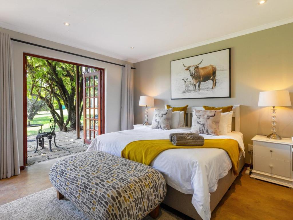 a bedroom with two beds with a cow on the wall at The Horseshoe Guesthouse in Midrand