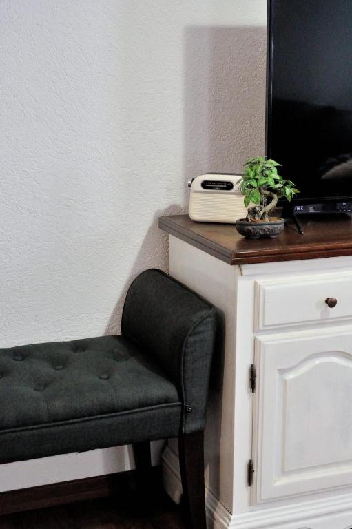 a black chair sitting next to a tv on a counter at Apartman Promaja in Široki Brijeg