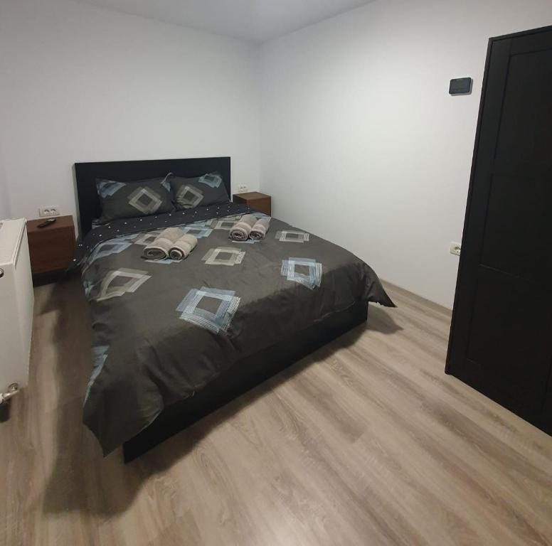 a bed with a black comforter in a bedroom at Parnica Home 4 in Dudeştii Noi