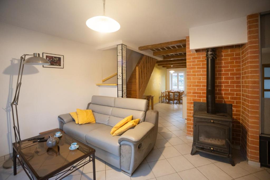 a living room with a couch and a wood stove at T3 Cosy - Art Déco in Villefranche-de-Rouergue