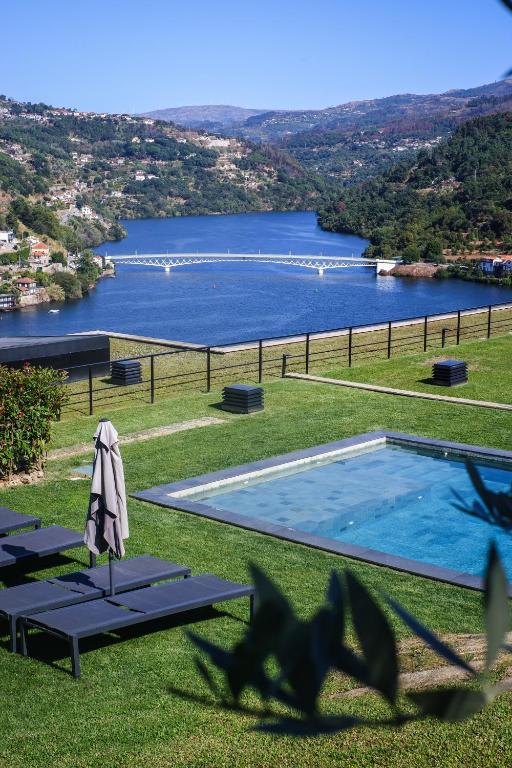 a swimming pool with a view of a lake at Douro Country House in Cinfães