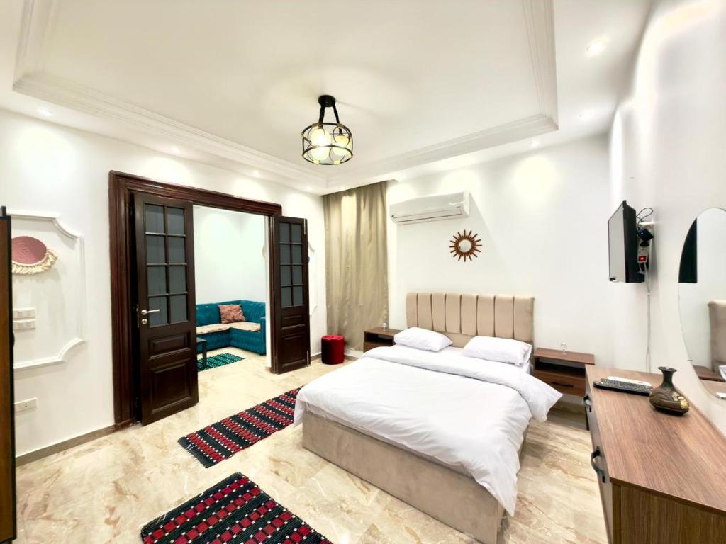 a bedroom with a bed and a desk and a table at TriPyramids Suites in Cairo