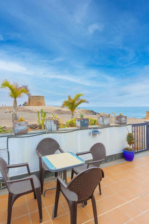 a patio with chairs and a table and the beach at Cotillo Jolanda in El Cotillo