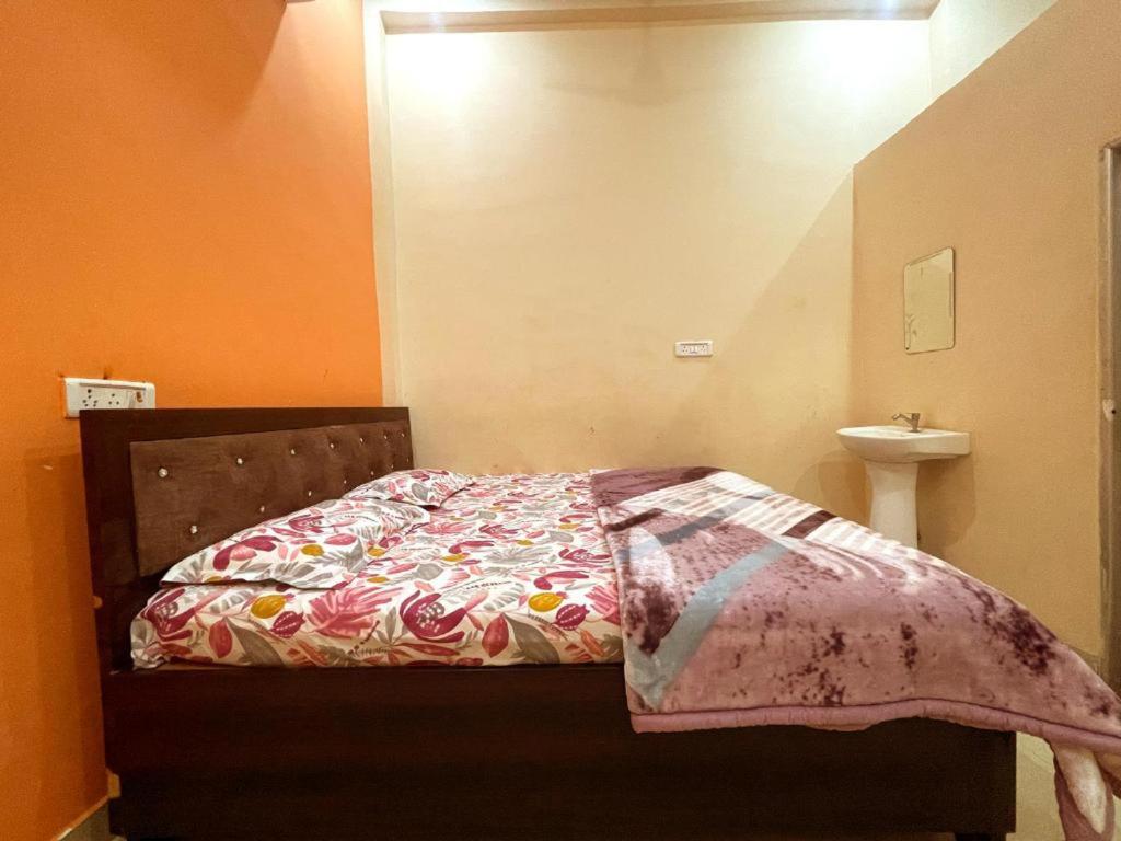 a bedroom with a bed and a sink at Kamla Sadan Palace in Ayodhya