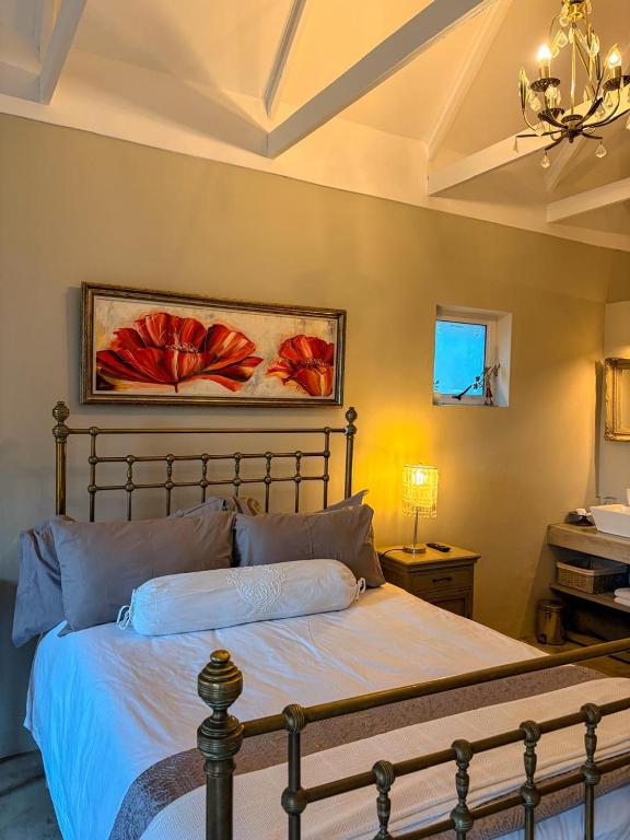 a bedroom with a bed and a painting on the wall at Winner in the Overberg in Bredasdorp