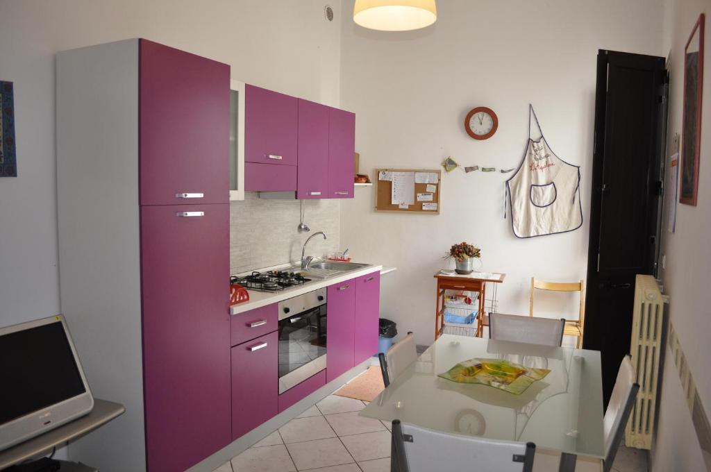 カンピ・サレンティーナにあるCasa Vacanza L'Aquiloneのキッチン(紫色のキャビネット、テーブル、テーブル・シドックス・シドックス付)