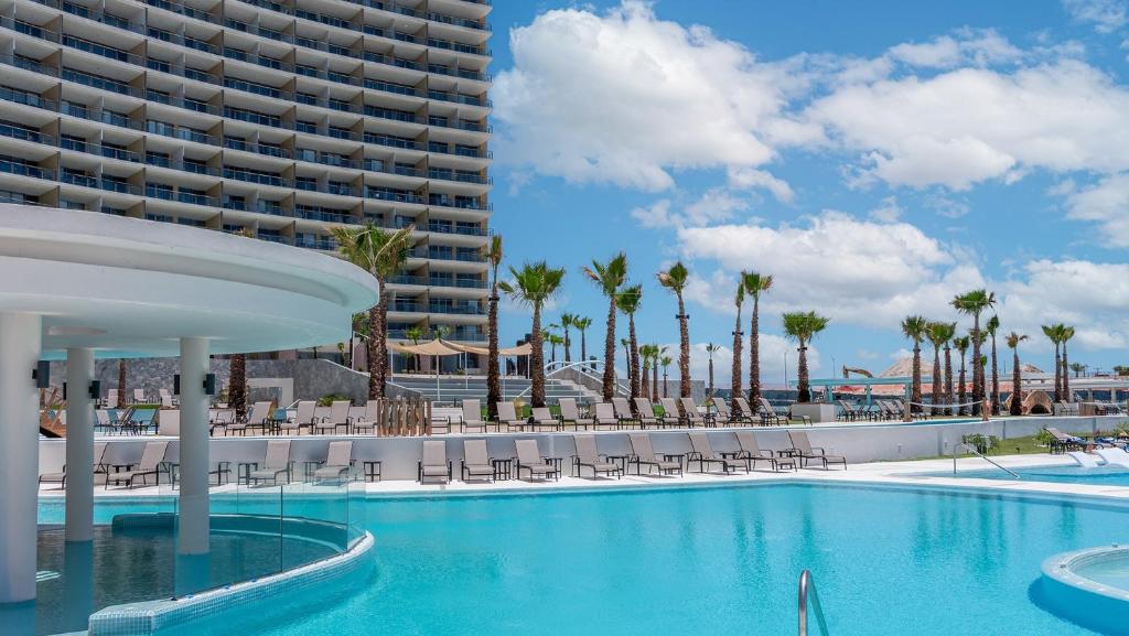 a swimming pool in front of a large building at Modern Seaside Retreat Boasting Unforgettable Scenery in Puerto Peñasco