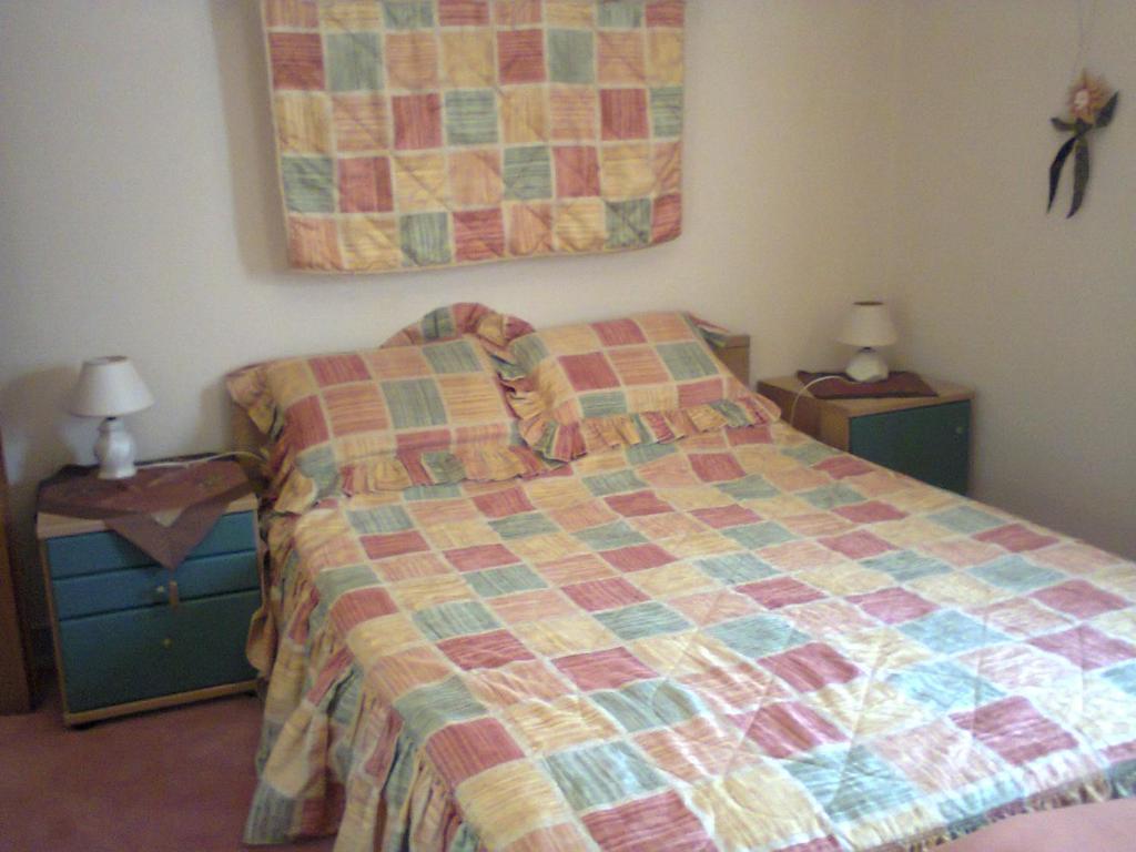 ein Schlafzimmer mit einem Bett mit einer Decke darauf in der Unterkunft Evgenia Apartment in Antikes Epidauros