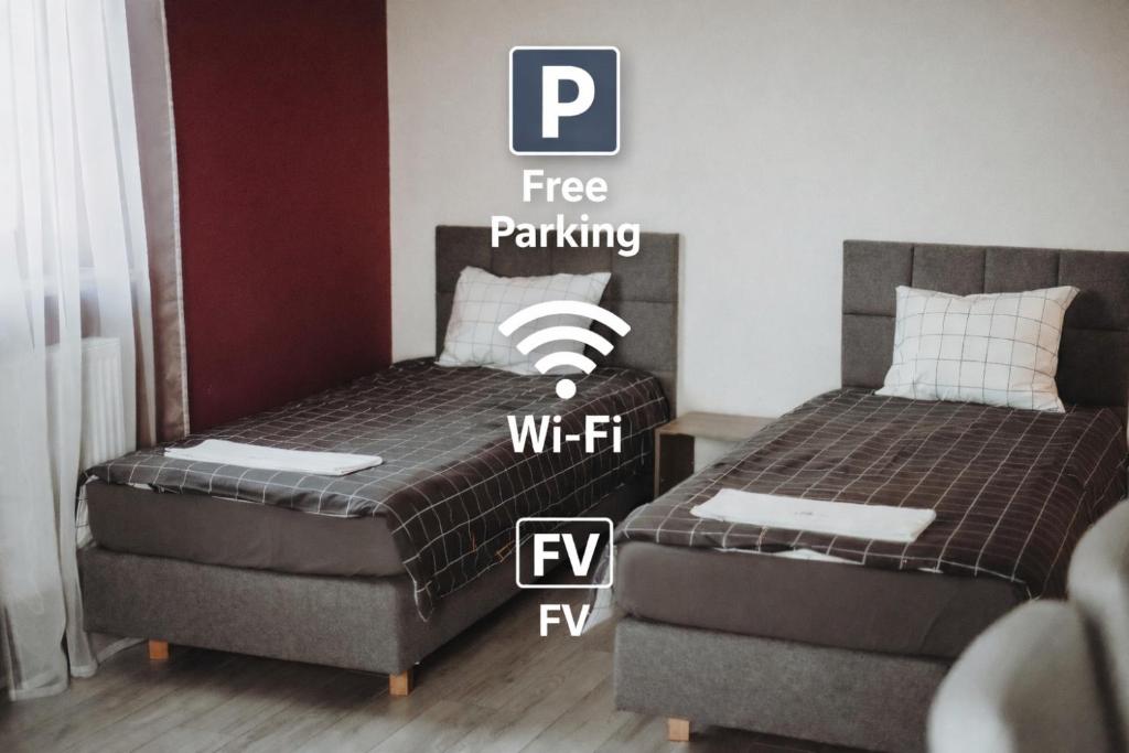 a bedroom with two beds and a sign that says free parking at Redwood Hostel by EASY RENT Apartments in Lublin