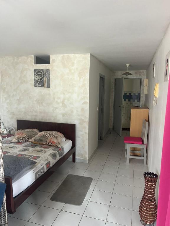 a bedroom with a bed and a chair in it at Kaz'a Diamant in Le Diamant