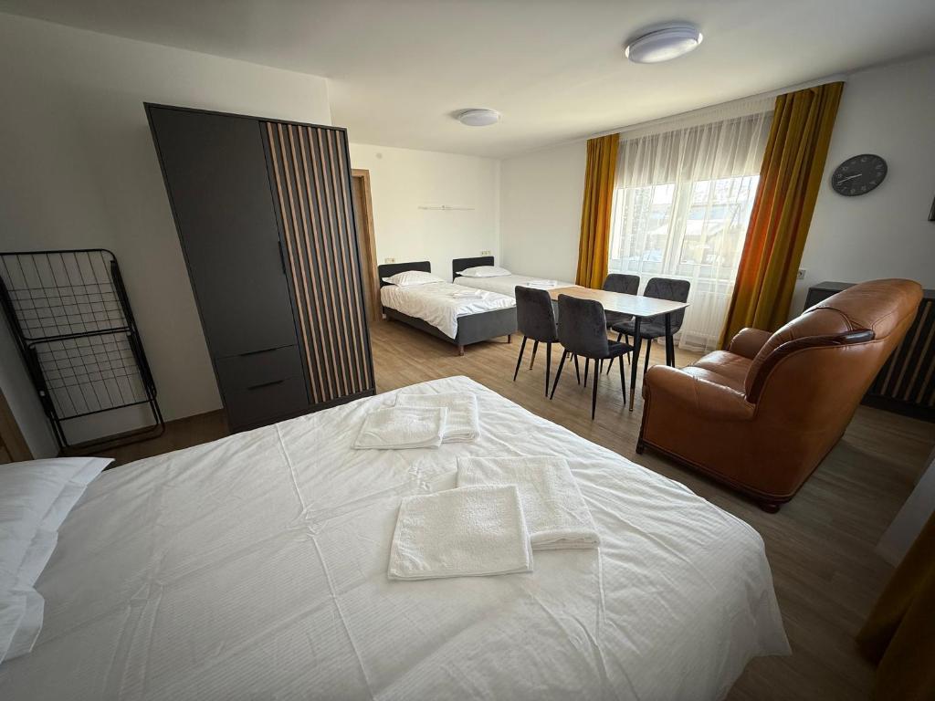 a bedroom with a bed and a table and chairs at SALGIRDO svečių namai in Kelmė