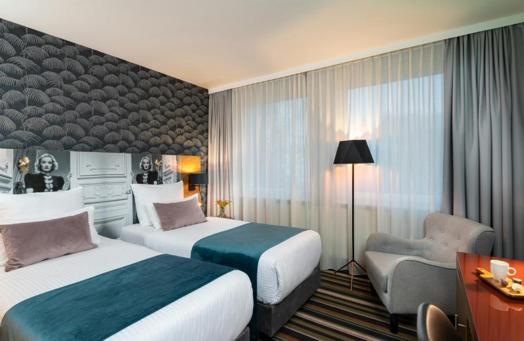 a hotel room with two beds and a chair at Leonardo Boutique Hotel Berlin City South in Berlin