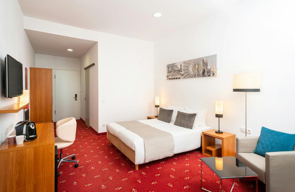 a hotel room with a bed and a couch at Leonardo Hotel Berlin KU'DAMM in Berlin