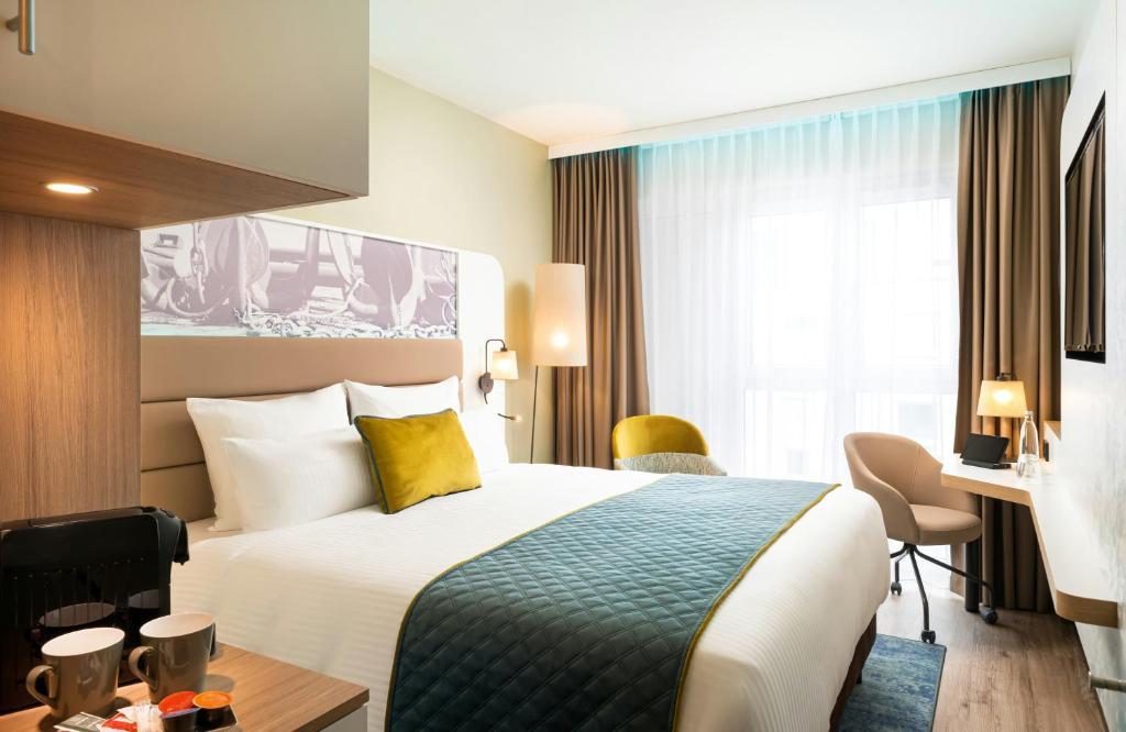 a hotel room with a bed and a desk at Leonardo Hotel Hamburg Altona in Hamburg