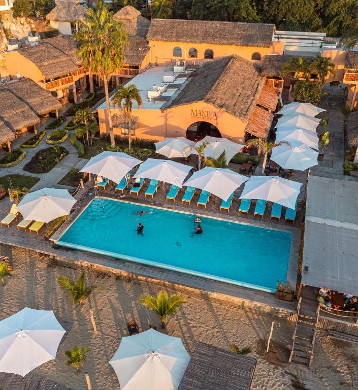 an overhead view of a resort pool with umbrellas at La Posada Hotel Boutique in Manzanillo