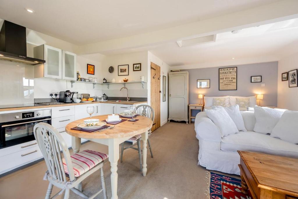 a kitchen and living room with a table and a couch at 1 Bed in Snape oc-sfgcs in Snape