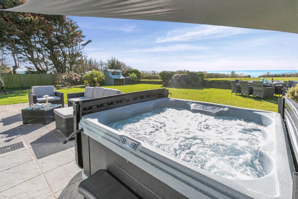 a jacuzzi tub on a patio at 5 Bed in Stibb oc-f31065 in Poughill