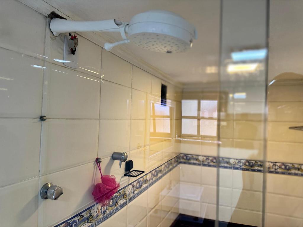 a bathroom with a shower with a pink umbrella at Casa do Abrahão in Angra dos Reis