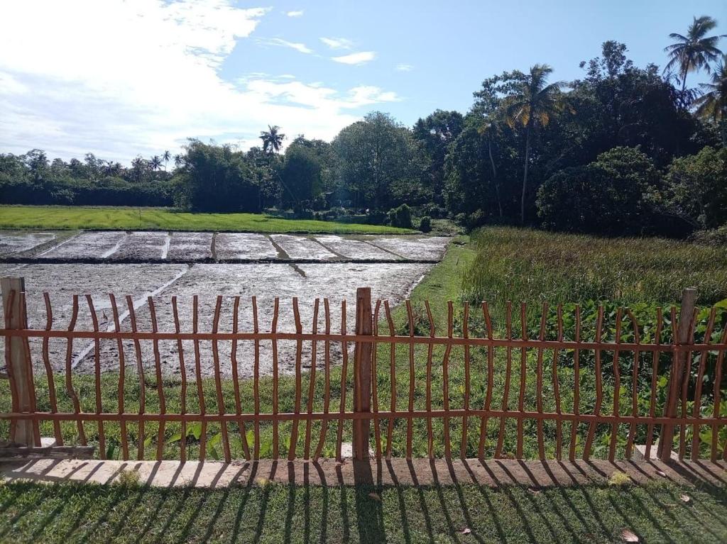 a fence in front of a river with trees at Villa Nimāmi in Ahangama