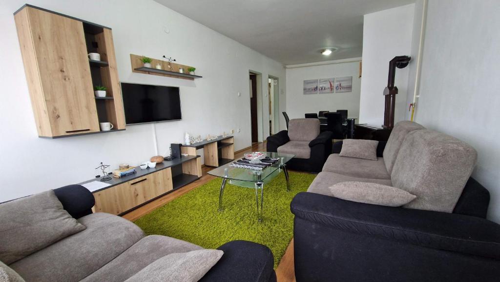 a living room with two couches and a tv at Apartman Dunja in Ruma