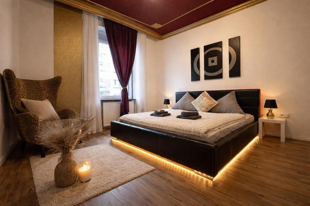 a bedroom with a bed and a chair with lights at Urban Spacious Bright Apartment with DanubeView in Linz