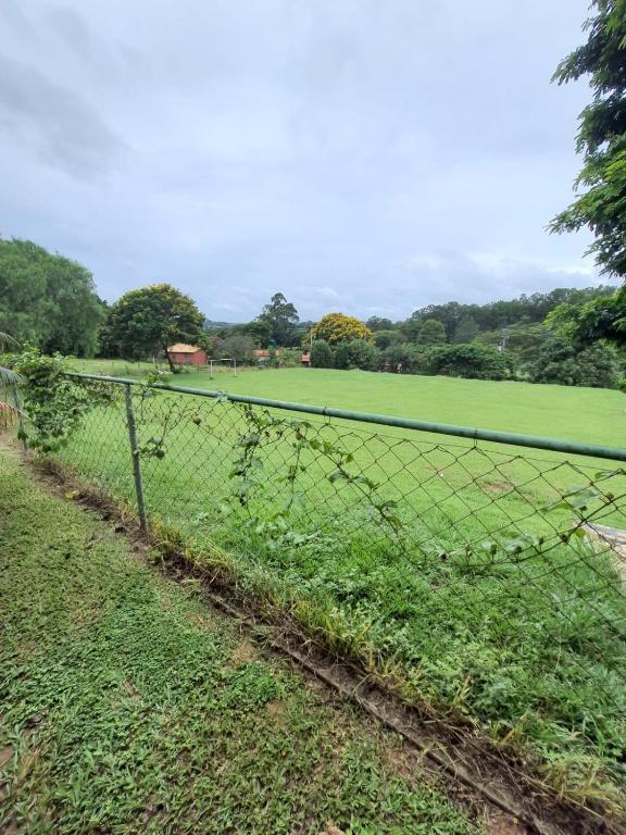 a chain link fence with a field in the background at Sítio Ubaitaba in Boituva