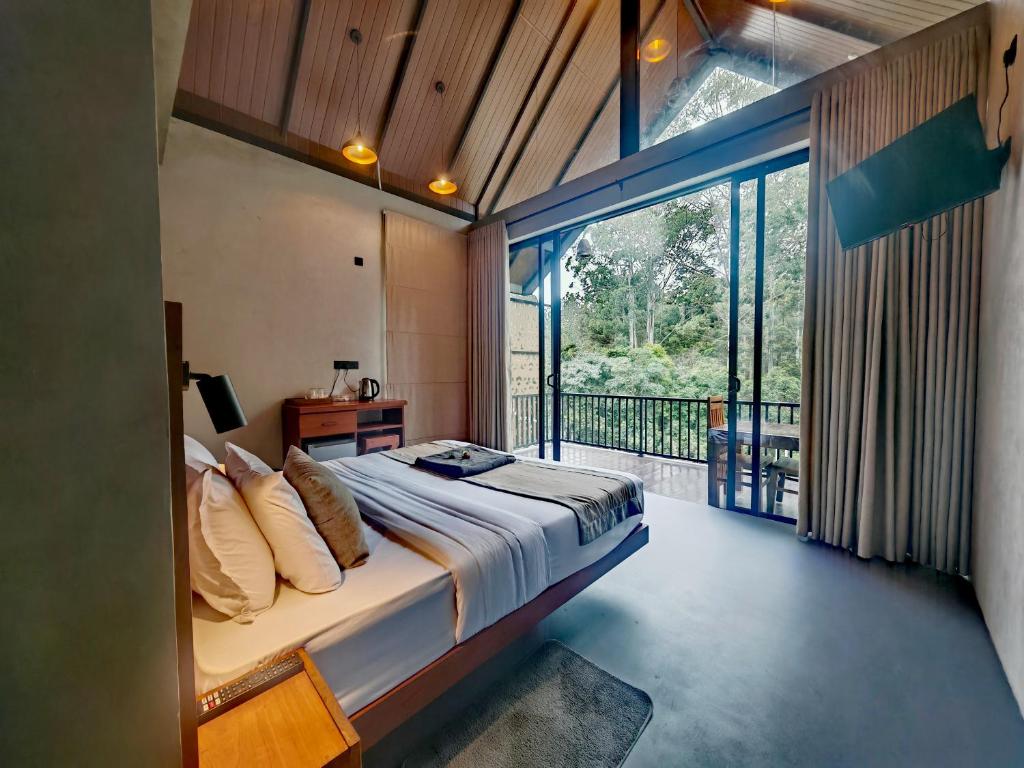 a bedroom with a large bed and a balcony at Liora Lodge Ella in Ella