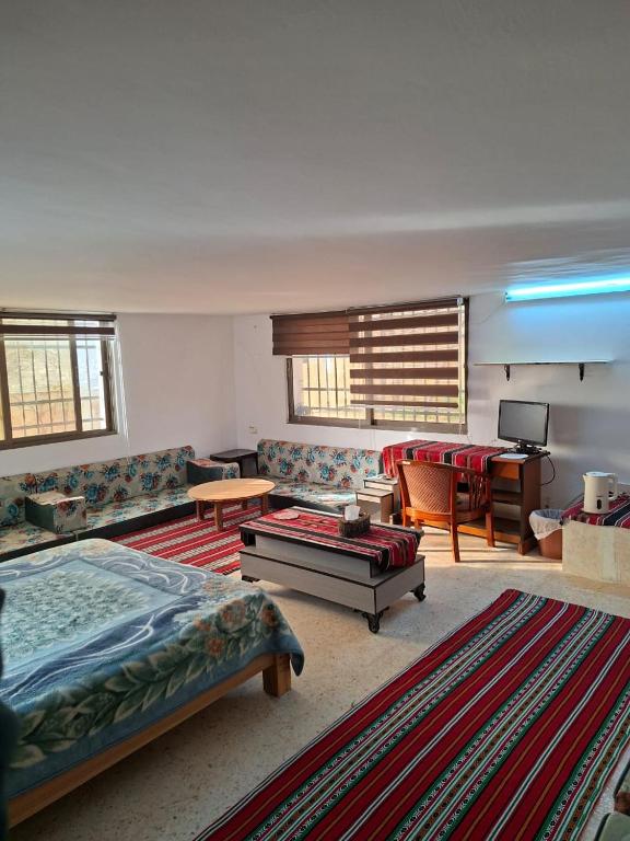 a living room with a bed and a couch and a table at Mountain Pad Overlooking Jerash - HQ Budget stay in Jerash
