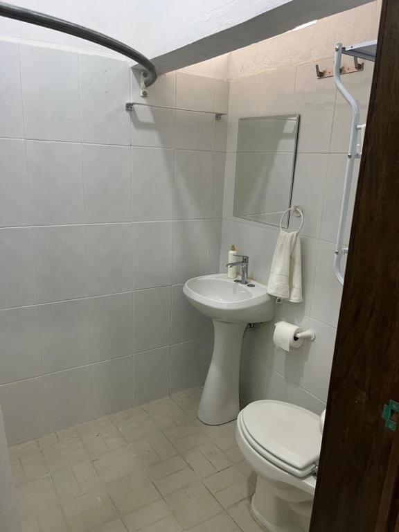 a white bathroom with a toilet and a sink at CASA DE LA ABUELa in Colima