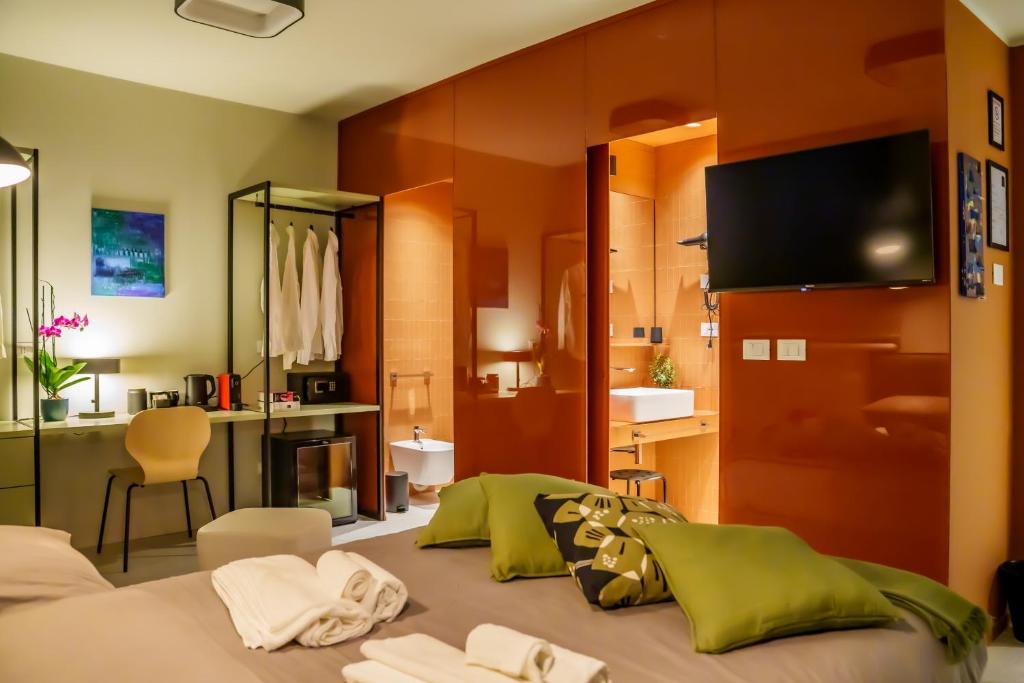 a bedroom with a bed with a tv on the wall at JDN Rooms in San Donato Milanese