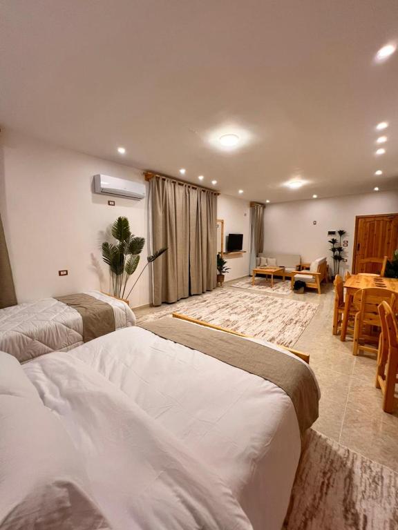 a bedroom with two beds and a living room at deluxe experience siwa in Siwa